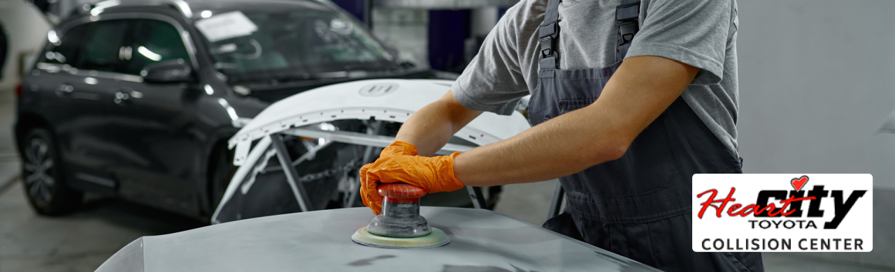 Certified auto body repair technicians working on a Heart City Toyota Collision Center vehicle.
